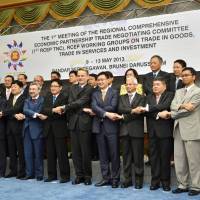 Hand in hand: Representatives of 16 Asia-Pacific economies pose for a photo Thursday in Brunei as they kick off a meeting on free trade. | KYODO