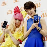 Wired for sound: Japanese pop artist Kyary Pamyu Pamyu (left) and actress Ayame Goriki pose with new KDDI smartphone models in Tokyo\'s Shibuya Ward on Monday. | KYODO