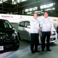 A car is born: Nissan Motor Co.\'s Chief Operating Officer Toshiyuki Shiga (left) and Mitsubishi Motors Corp. President Osamu Masuko shake hands Monday in front of a DAYZ minicar their companies developed in Kurashiki, Okayama Prefecture. | KYODO