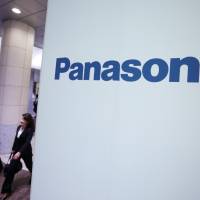 Finding a way forward: Pedestrians pass a Panasonic Corp. ad outside the company\'s Tokyo headquarters in mid-May. Panasonic said Thursday it plans to pursue more mergers and acquisitions and collaborations with other firms to improve profitability. | BLOOMBERG