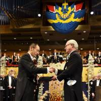 Shinya Yamanaka, joint winner of the 2012 Nobel Prize in physiology or medicine, receives his prize from Sweden\'s King Carl XVI Gustaf during the award ceremony at the Stockholm Concert Hall on Monday. | REUTERS/KYODO