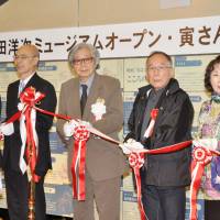 Making the cut: Lauded film director Yoji Yamada (center) takes part in a tape-cutting ceremony Saturday for a new museum dedicated to his works in Katsushika Ward, Tokyo. | KYODO
