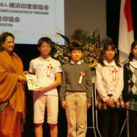 Indian Ambassador Deepa Gopalan Wadhwa presents the manga \"Secrets of India\" to Japanese elementary school students at the embassy in Tokyo on Dec. 14. | CHIHO IUCHI
