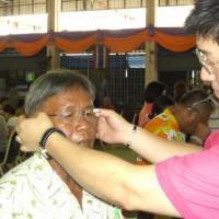 Made in Japan: A Thai resident tries out a pair of donated glasses in Bangkok in November. | MEGANE PLAZA/CHUNICHI SHIMBUN