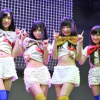 Blue chips: Machikado Keiki Japan members (from left) Hinako Kuroki, Kanon Mori, Yuki Sakura and Jun Amaki show how they shortened their costumes to reflect the rise in the Nikkei stock average. Girl group bases style on Nikkei ups and downs