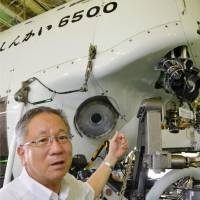 Grand tour: Hiroshi Kitazato of the Japan Agency for Marine-Earth Science and Technology points at the Shinkai 6500 manned submersible Sunday in Rio de Janeiro. | KYODO
