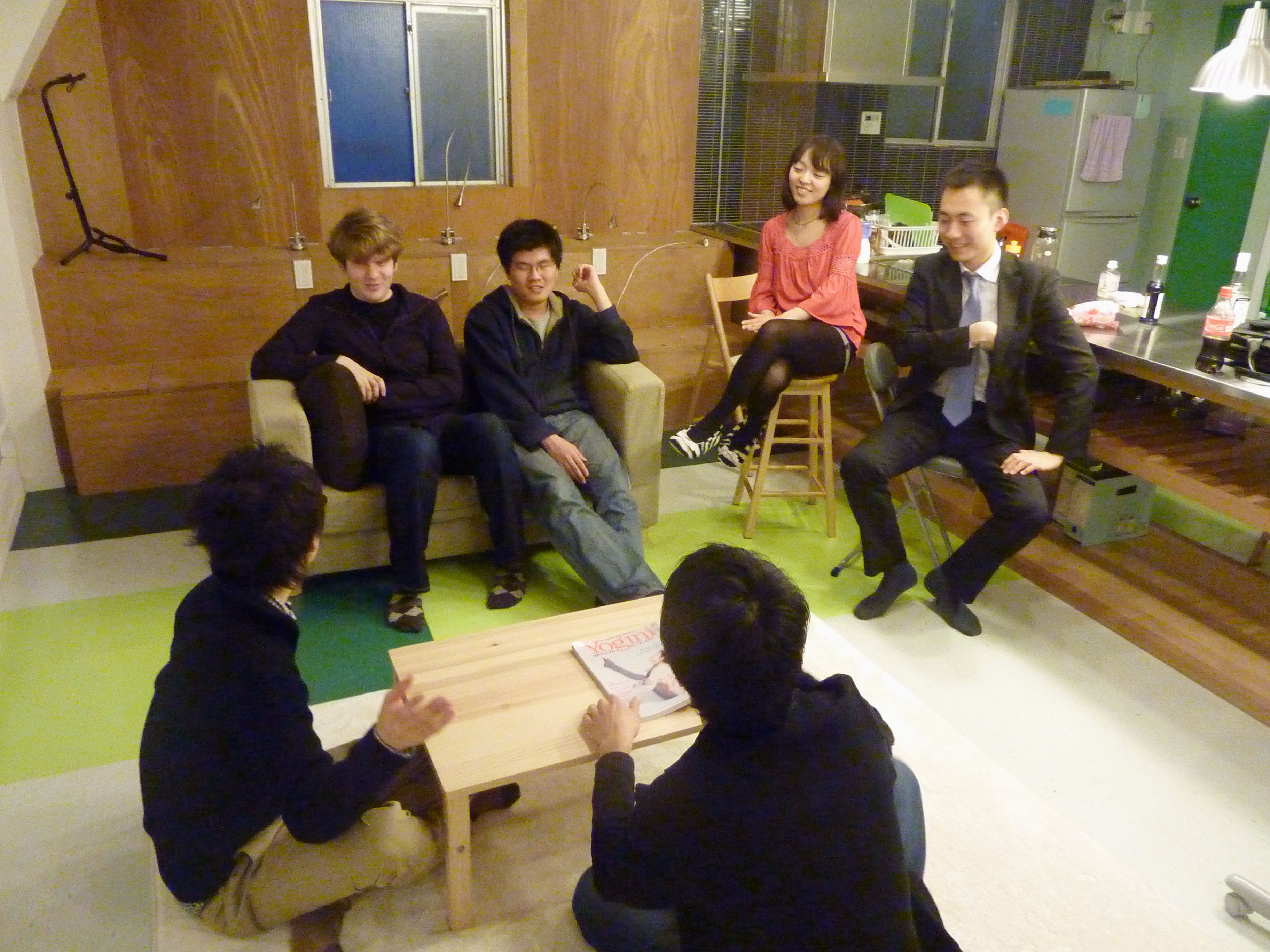 Roommates: Students from the United States and South Korea chat recently with a Japanese office worker in a 'share house' in Chiyoda Ward, Tokyo. | KYODO