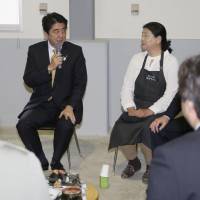In the field: Prime Minister Shinzo Abe talks with farmers in tsunami-hit areas in Sendai on Sunday. Abe said that the Tokyo Metropolitan Assembly election in June will be a litmus test for his government ahead of the Upper House election in July. | KYODO