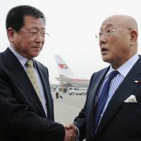 Making contact: Isao Iijima (right), an adviser to Prime Minister Shinzo Abe, is greeted by Kim Chol Ho, vice director of the North Korean Foreign Ministry\'s Asian Affairs Department, upon his arrival Tuesday at Pyongyang airport. | KYODO