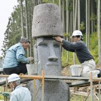 Like a rock: Workers install a stone Moai statue replica from Chile Thursday in Minamisanriku, Miyagi Prefecture. | KYODO