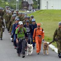 Search on: Self-Defense Force personnel and others leave Tuesday morning to search for two elementary school children from Osaka who were reported missing Monday on a mountain in Shiga Prefecture. The two later found their way to safety. | KYODO