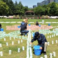 Happy 110th: Organizers of \"Hibiya Akari Terrace,\" one of the main events to mark the 110th anniversary of Tokyo\'s Hibiya Park this weekend, prepare candles on Friday. | YOSHIAKI MIURA
