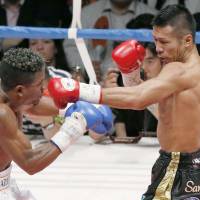 WBA super featherweight champion Takashi Uchiyama connects with a punch at Venezuelan challenger Jaider Parra. | KYODO