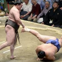 Simply the best: Hakuho overpowers Okinoumi on Friday at the Summer Grand Sumo Tournament. | KYODO
