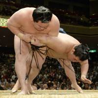 Impressive strength: Yokozuna Hakuho (left) outduels Goeido on Tuesday at the Summer Grand Sumo Tournament. | KYODO