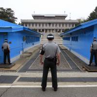 Three South Korean soldiers stand guard at Panmunjom the same day. Sibling spy case spotlights North Korean defectors