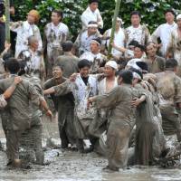 Young men and women jump in a muddy rice field before planting starts in Hioki, Kagoshima Prefecture, on Sunday. During the 400-year-old \"Seppetobe\" annual event to wish for a good harvest, some 80 people jumped around in the paddy for 40 minutes after drinking \"shochu\"distilled spirits. | KYODO