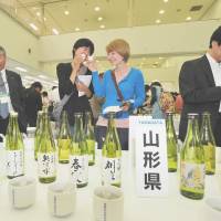 Poland native Hanna Takemoto (right) and her friend, Risa Kamishima, drink sake at a tasting event in Tokyo\'s Ikebukuro district Friday. About 400 kinds of rice wine were served during the one-day event. | YOSHIAKI MIURA