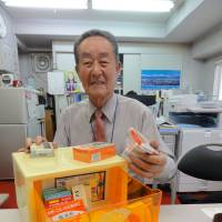 Medicine man: Masao Inoya, immediate past chairman of the Tokyo-to Iyakuhin Haichi Kyokai (Tokyo Metropolitan Medicine Placement Association), displays some of the medicines that stock an okigusuri medicine box. | SATOKO KAWASAKI