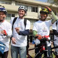 Helping others: Charity cyclists, including John Morris (second from left) and Don Kalubowila (second from right) get ready outside Meisei Gakuen School for the Deaf in Shinagawa Ward, Tokyo, on Friday morning for their eight-day ride to Osaka. | YOSHIAKI MIURA PHOTOS