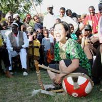 Testing time: Eriko Mukoyama plays the nyatiti before 200 Luo people in the village of Karapul near Lake Victoria, Kenya, in November 2005. With this performance, she was certified by the Luo as the first female master of their traditional instrument. | ERIKO MUKOYAMA PHOTO