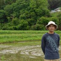 Mixed outlook: Organic farmer Naoki Tachikawa, who can see many dying red pines in the woods around his paddies. | WINIFRED BIRD PHOTO