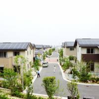 Sunny days: Visitors inspect solar-powered residential quarters developed by Daiwa House Industry Co. in Sakai, Osaka Prefecture, on Thursday. | KYODO