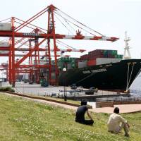 Outbound: A ship is loaded with products bound for overseas markets at a shipping terminal in Tokyo on April 18. | BLOOMBERG