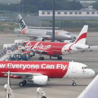 Crosscheck: A pair of AirAsia Japan jetliners sit on the tarmac at Narita International Airport last July. | KYODO