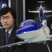 Approaching takeoff speed: Michimasa Fujino, president of Honda Aircraft Co., poses Wednesday by a model of the firm\'s business jet. | BLOOMBERG