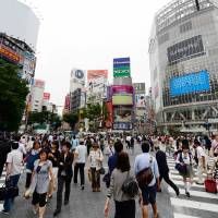 By the numbers: People cross the busy intersection in front of JR Shibuya Station on June 6. In 2015, residents of Japan, including foreigners, will each be assigned an ID number whose use will start in 2016. | AFP-JIJI
