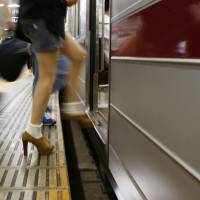 Through the gap: A passenger boards the Hibiya Line on Monday at Tokyo\'s Roppongi Station, where a woman slipped through the gap between the platform and a train the previous day. | KYODO