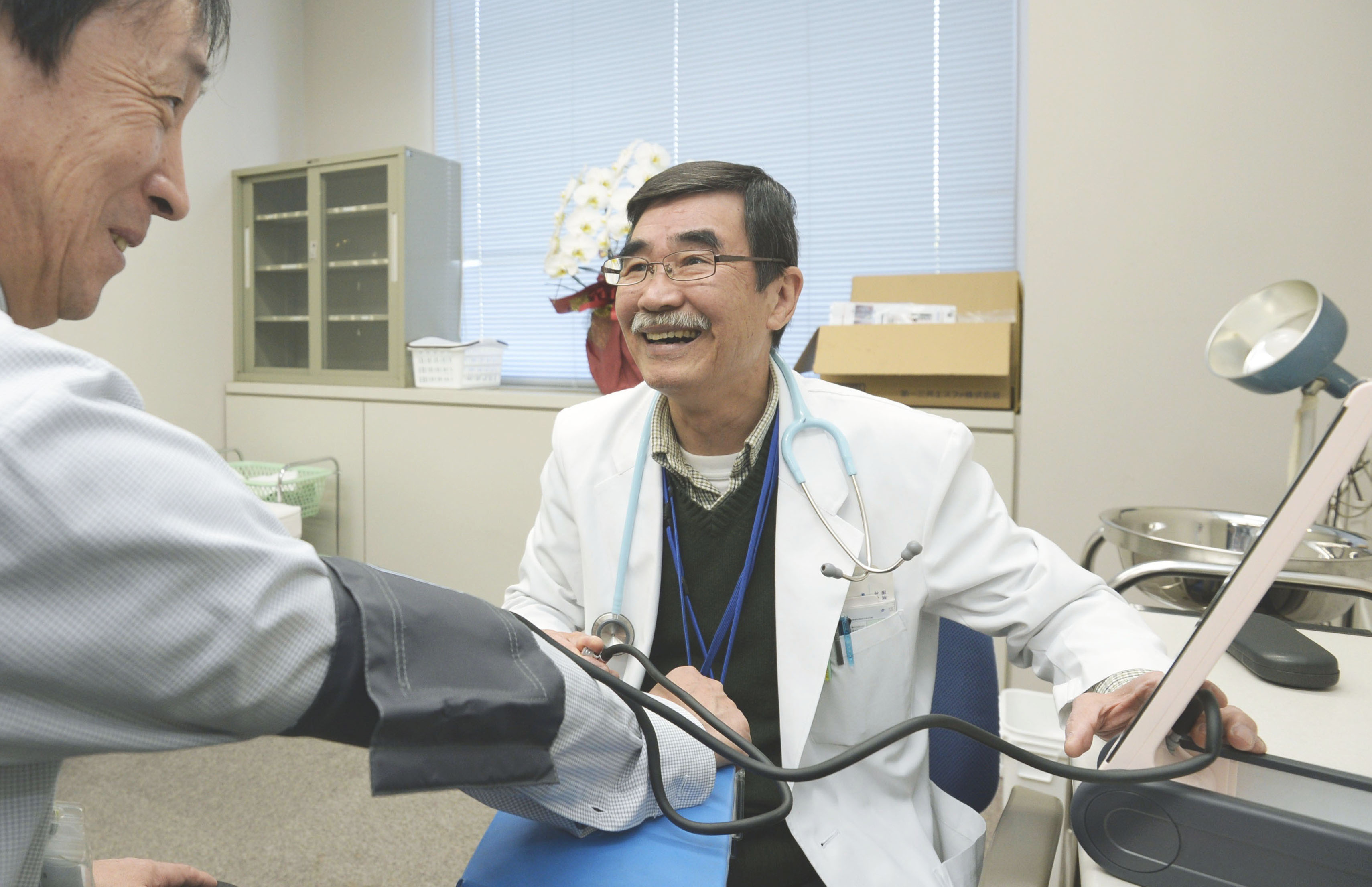 Service with a smile: Dr. Shunji Sekine measures the blood pressure of a local official May 9 at a temporary clinic in the town of Namie, Fukushima Prefecture. | KYODO
