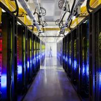 Your life in wires: The campus-network room of a data center in Council Bluffs, Iowa, is seen in this photo provided by Google Inc. Reams of data are coursing through the fiber cables running along the yellow cable trays near the ceiling. | AP