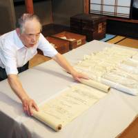 Ancient court life: Osamu Nawa, head of Yomei Bunko, a library in the city of Kyoto storing diaries of Fujiwara no Michinaga, shows the scrolls Wednesday. | KYODO