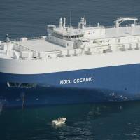 Search for evidence: A Japan Coast Guard boat approaches the Norwegian car carrier NOCC Oceanic off Sendai on Tuesday morning to determine whether it was involved in a collision Sunday with a tuna trawler, whose skipper remains missing. | KYODO