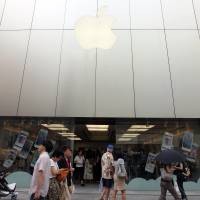 Taking a bite: Pedestrians walk past an Apple Inc. store in Tokyo\'s Ginza district Sunday.  | BLOOMBERG