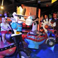 Three-year-old Yusaku Sobue and a reporter try out rides based on the popular comic \"One Piece\" Tuesday during a media preview of J-World Tokyo, a new amusement park to open Thursday in the Ikebukuro district. The park is operated by the Bandai-Namco entertainment group. | YOSHIAKI MIURA