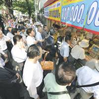 People swarm to buy Summer Jumbo lottery tickets Wednesday at the popular booth in Tokyo\'s Ginza district. The top prize &#8212; &#165;300 million &#8212; will be announced Aug. 13. | KYODO