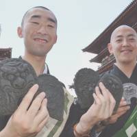 Buddhist monks at seventh century Yakushiji Temple in the city of Nara show off special cookies baked in the shape of \"onigawara\" (roof ornaments) found in traditional Japanese architecture. The temple will teach children how to make the cookies using nearly the same techniques used to make the ornaments, later this month. | KYODO