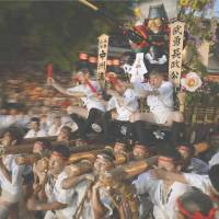 Men carry a festival float through the grounds of Kushida Shrine in the city of Fukuoka early Monday on the last day of the annual Hakata Gion Yamakasa festival. Seven teams, each carrying a float that weighed 1 ton, competed along the 5-km course in the Hakata area to see who was the fastest. | KYODO