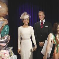 A visitor poses for a picture with wax figures of Britain\'s Prince William and wife, Kate, at Madame Tussauds in Tokyo on Tuesday as balloons are displayed in celebration of the birth of the royal couple\'s first child. | SATOKO KAWASAKI