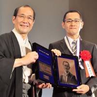 Kyoto University professor and Nobel laureate Shinya Yamanaka (right) is made an honorary citizen of Kyoto by Mayor Daisaku Kadokawa during a ceremony at the Kyoto International Conference Center on Tuesday. The stem cell expert who won the Nobel last year joked that he has always wanted to be a Kyoto citizen even though he lives in the city of Osaka. Yamanaka has worked at Kyoto University since 2004. | KYODO