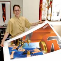 Woodblock-inspired: Maia Maniglier, at her office in Tokyo\'s Ichibancho district, shows off artwork she developed for a restaurant in the Asakusa district. The poster depicts Asakusa\'s famous Sanja Festival and, although designed on a computer, incorporates the aesthetic of traditional ukiyo-e prints. | YOSHIAKI MIURA PHOTO