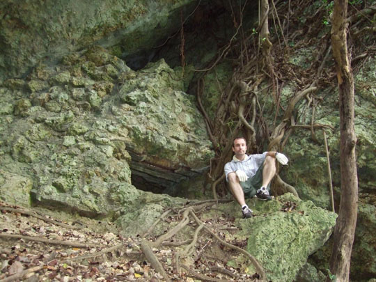 At ease: The author sits beside a Japanese machine-gun slit in southern Okinawa that bullet holes in the rock testify as the scene of deadly combat in 1945. | JON MITCHELL