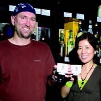 Johnnie Stroud and his wife Taiko raise sake cups at their Sake Nomi shop in Seattle. | COURTESY OF JOHNNIE STROUD