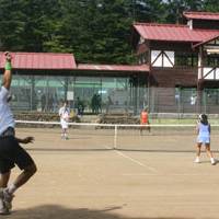 Big shots: Michael Mentzer and Sanae Ota (far court) compete in the final of the mixed doubles competition at the Karuizawa International Tennis Tournament earlier this month (left). | EDAN CORKILL PHOTO