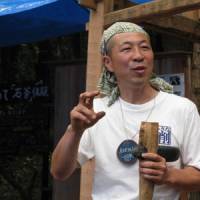 Top man: Event organizer Kunihiro Amemiya with his stone ax. | HIROSHI HIROSE PHOTO