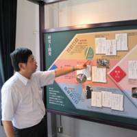 Plan of attack: Museum curator Akira Yamada points to a panel explaining biological warfare research conducted at the Noborito laboratory. | MARK SCHREIBER PHOTO