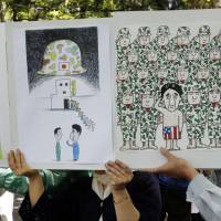 Fair satirical game: Protesters hold posters ridiculing Prime Minister Shinzo Abe during a rally against the Liberal Democratic Party\'s plan to amend the Constitution on March 3, the Constitution Day national holiday, in Tokyo. | AP